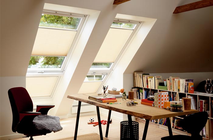 Tagvinduer i et møbleret rum, der illustrerer VELUX-anvendelsen
